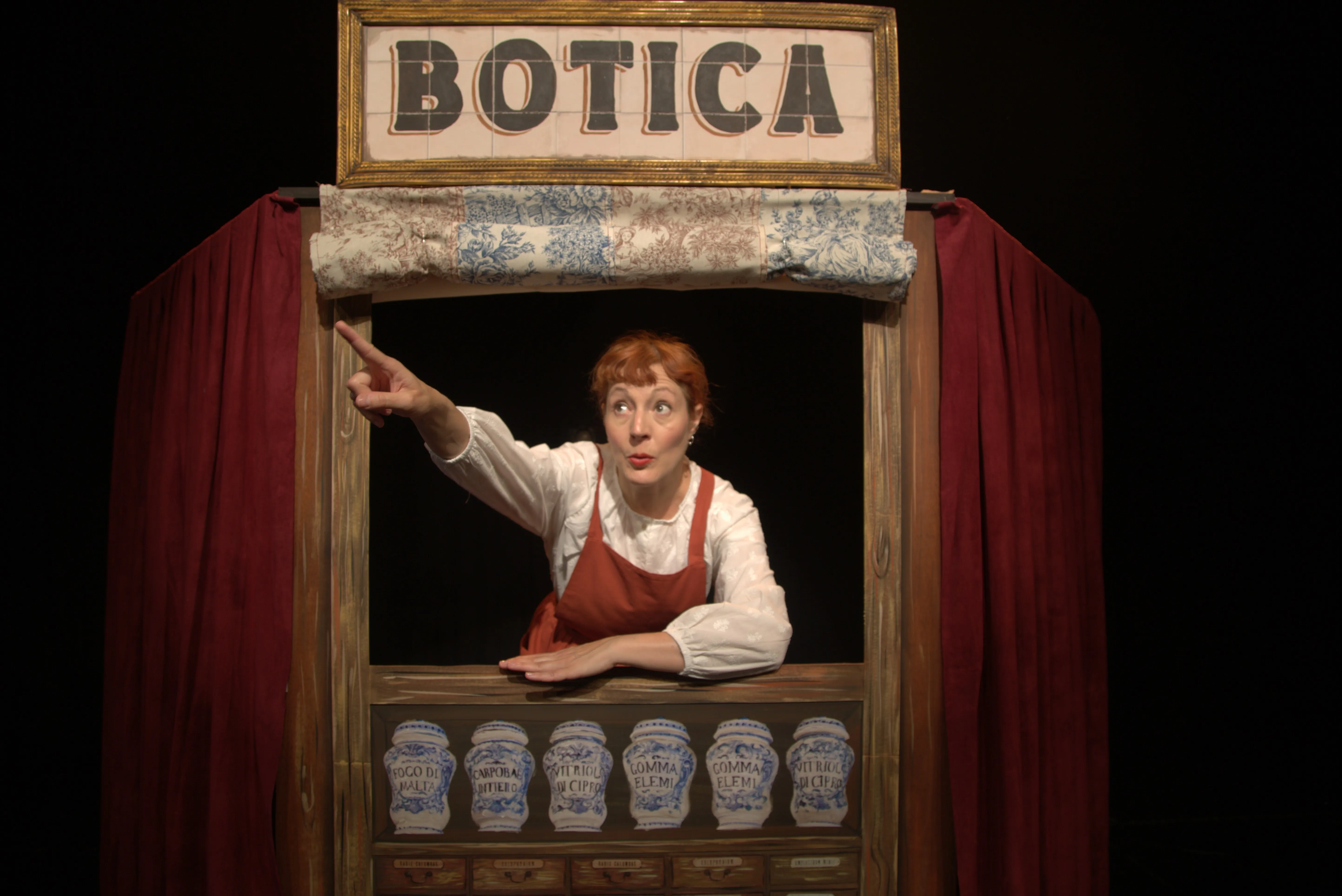 Jara señala hacia lo alto desde el mostrador de la botica