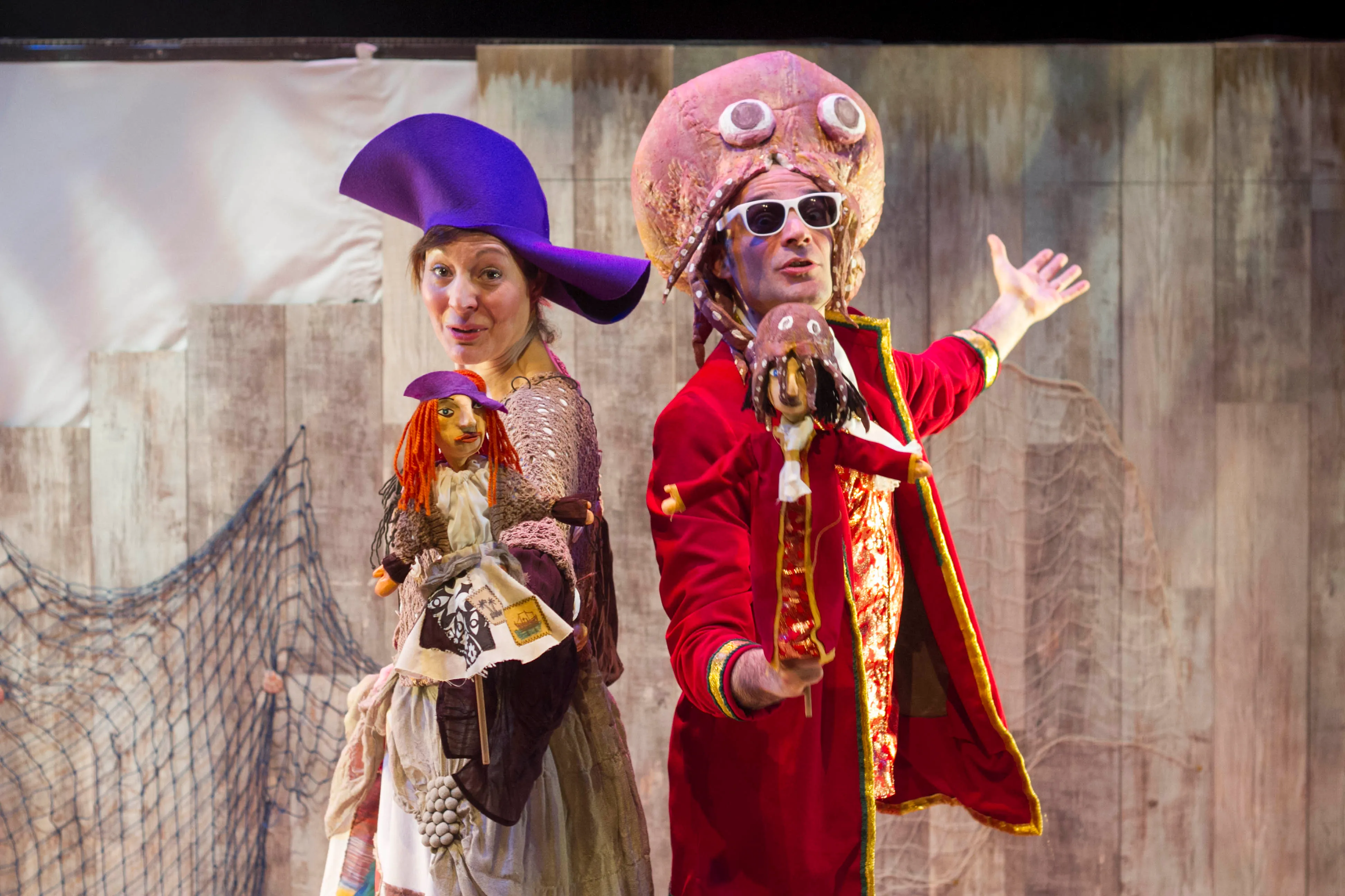 Los dos actores, vestidos de personajes de Shakespeare, sonríen con títeres en la mano